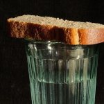 Рюмка водки и кусок хлеба возле фото умершего